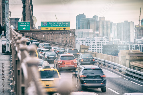 Cars speeding at sunset on Brooklyn Bridge at sunset, Manhattan. One of the most iconic bridges in the world, NY - USA.