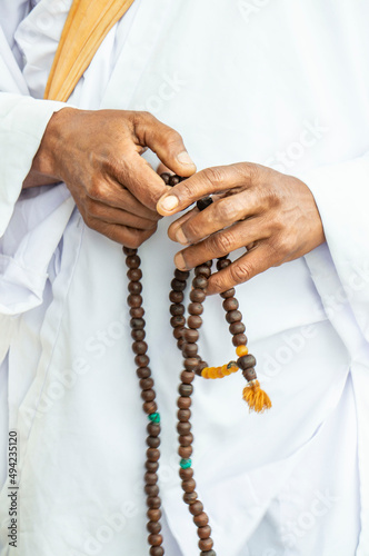 closeup male hands holding a rosary or prayer beads