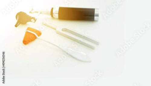 Tuning fork and Blur Otoscope and hammer jerk on white floor  top view with copy space