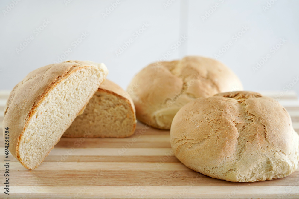 Close-up of homemade bread on wooden table. Rising price of basic needs.
