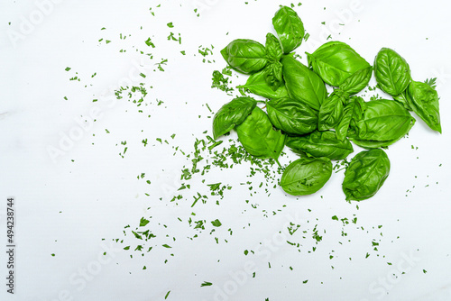 Fresh basil leaves on a white marble surface. Fresh  healthy and natural food concept. Copy space.