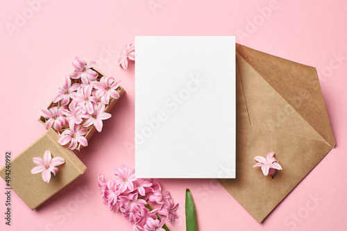 Greeting card mockup with envelope and spring hyacinth flowers on pink background