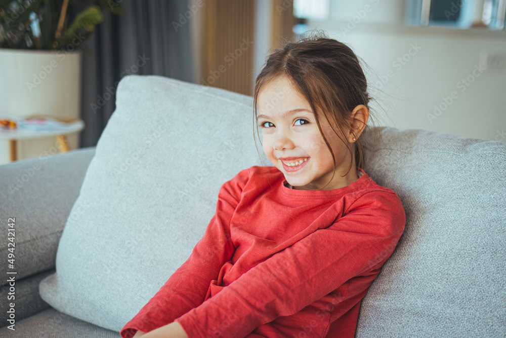 Stylish girl with pretty face at home. Little girl with long hair. Beauty and kid fashion with healthy hair. Portrait of a happy laughing child girl Stylish girl with pretty face at home. Little girl with long hair. Beauty and kid fashion with healthy hair. Portrait of a happy laughing child girl