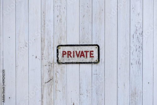 Private sign in red text on a wooden background