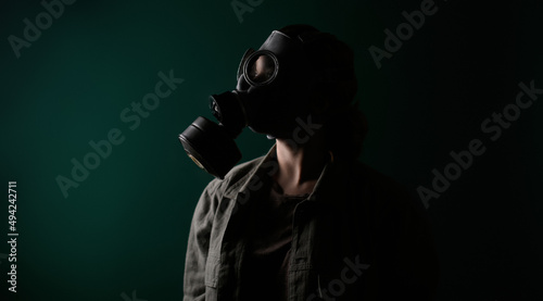 Photo of a military man in a gas mask, apocalypse, nuclear weapons, atomic explosion of a station, chemical and nuclear weapons protection. Girl in a mask on a green background, war.