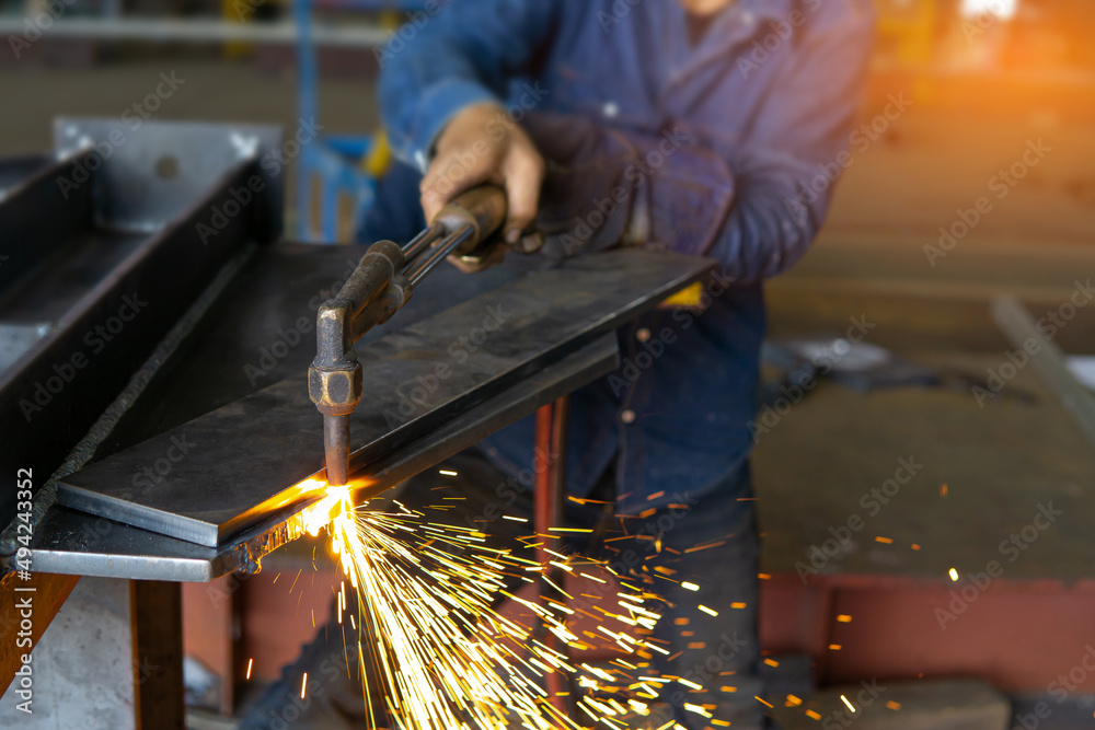 Close up hand a worker holds the gas cutting head to cut the steel