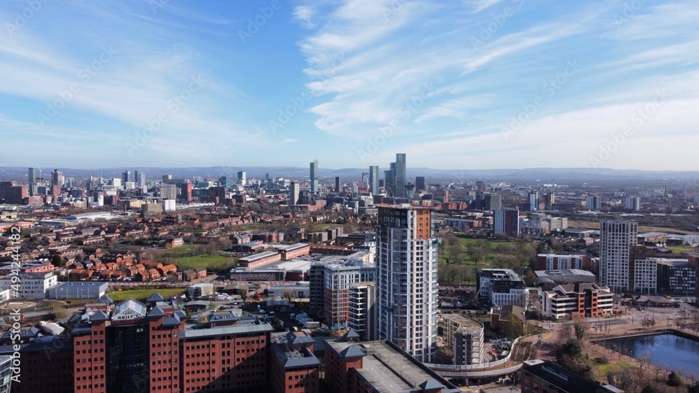 Naklejka premium Drone image of Salford Quays with modern buildings and landmarks and views towards Manchester. 