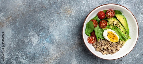 Quinoa buddha bowl with avocado, egg, tomatoes, spinach and sunflower seeds on a light background. Homemade food. Healthy, clean eating. Vegan or gluten free diet, Long banner format. top view