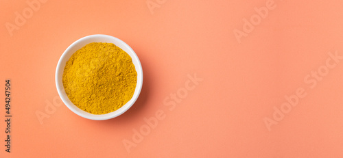 Organic curry yellow powder in the ceramic bowl - Healthy food photo