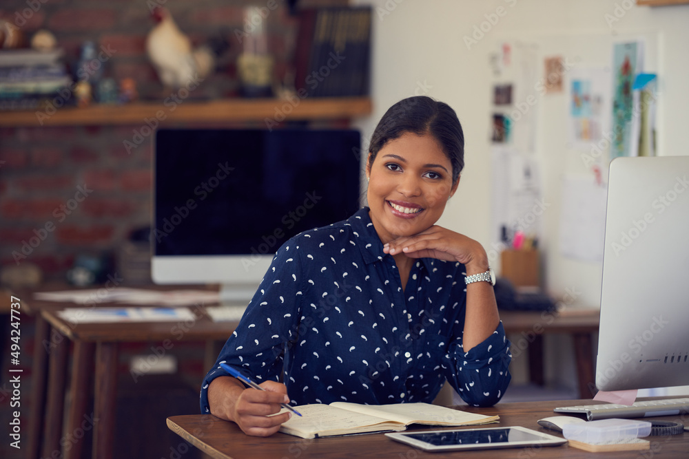 My occupation is my passion. Portrait of a young businesswoman writing notes at her desk in a modern office. My occupation is my passion. Portrait of a young businesswoman writing notes at her desk in a modern office.