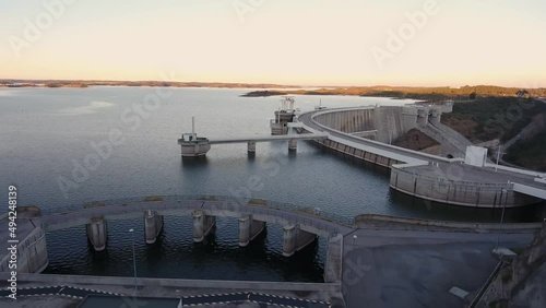 Portuguese hydroelectric power station on the dam of the Alqueva Lake river aerial view. During sunset buildings, maintenance photo