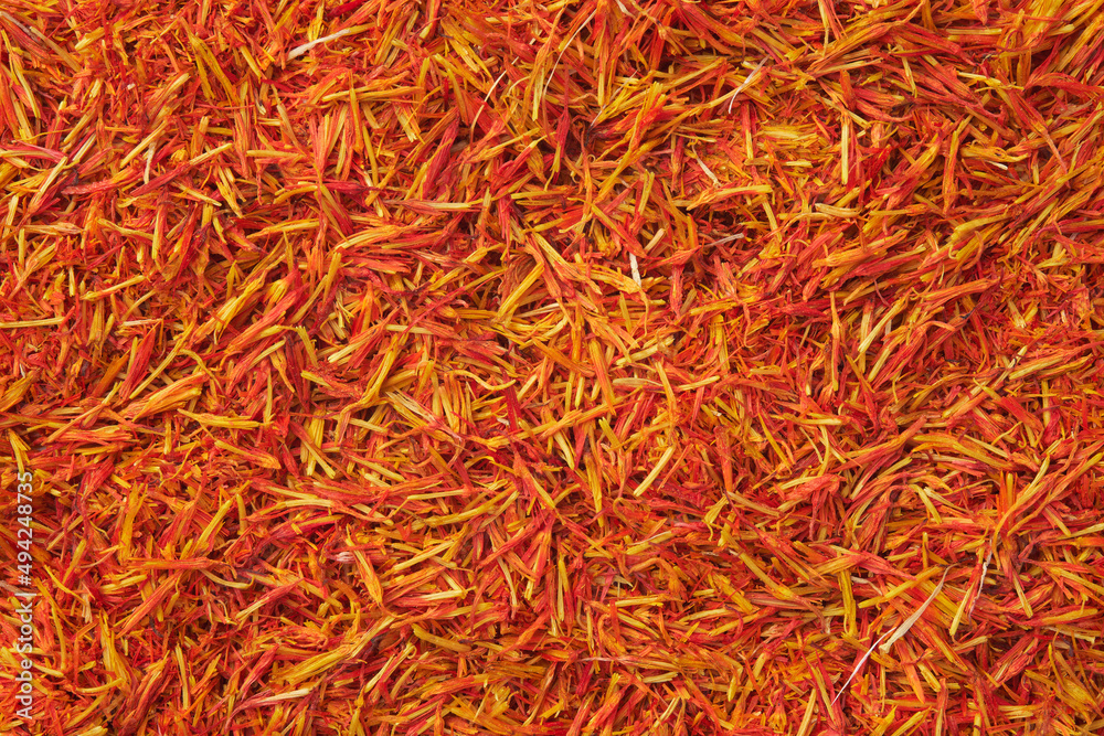 Fototapeta premium Saffron seasoning background. Organic Saffron or alternative to saffron - Safflower spice texture closeup.