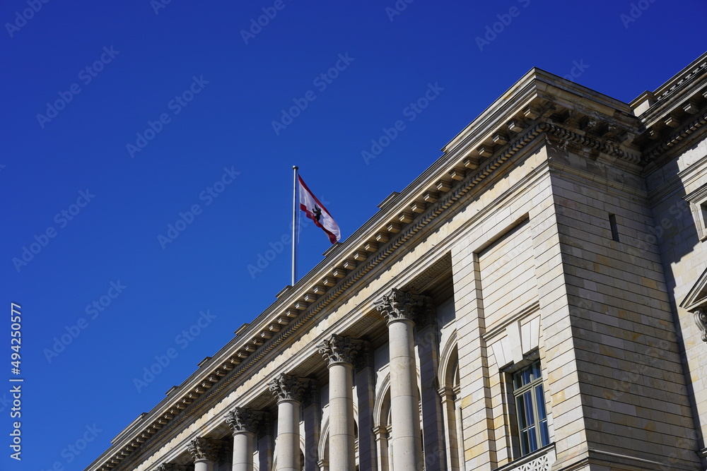 Das Berliner Abgeordnetenhaus mit wehender Fahne bei blauem Himmel und Sonnenschein
