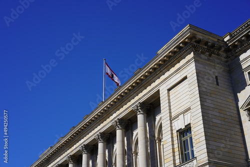 Das Berliner Abgeordnetenhaus mit wehender Fahne bei blauem Himmel und Sonnenschein