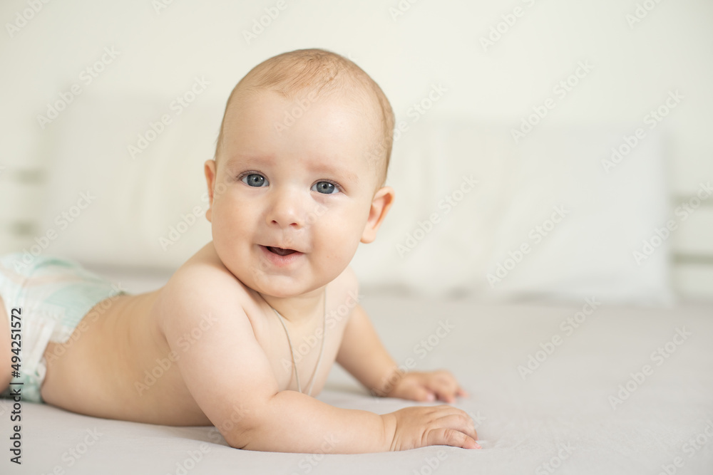 Adorable baby boy in white bedroom. Newborn child relaxing in bed. Family morning at home. Adorable baby boy in white bedroom. Newborn child relaxing in bed. Family morning at home.