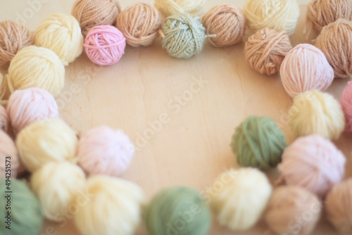 Cozy homely atmosphere. Female hobby knitting. Yarn in warm colors. Pink, peach, beige, white and green. The beginning of the process of knitting a women's sweater. Frame of yarn.