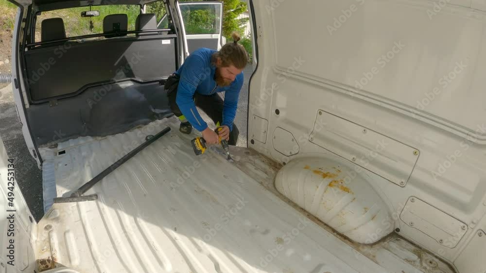 Young Man brushing inside of the Campervan for rust treatment. Veteran ...