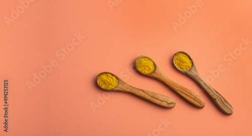 yellow curry spice in three wooden spoons - healthy food