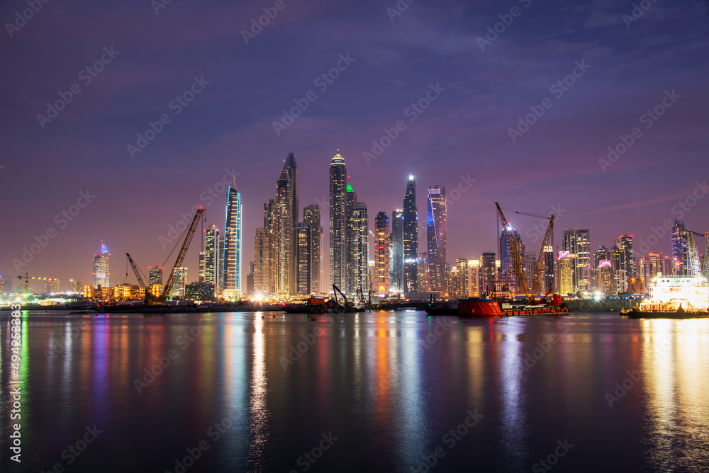 Dubai marina skyline at night with water reflections, United Arab Emirates