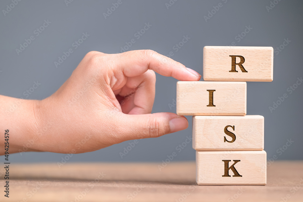 Hand pull out the woodblocks in the stack, try to keep the balance but have a risk to make it down, financial and investment concept Hand pull out the woodblocks in the stack, try to keep the balance but have a risk to make it down, financial and investment concept
