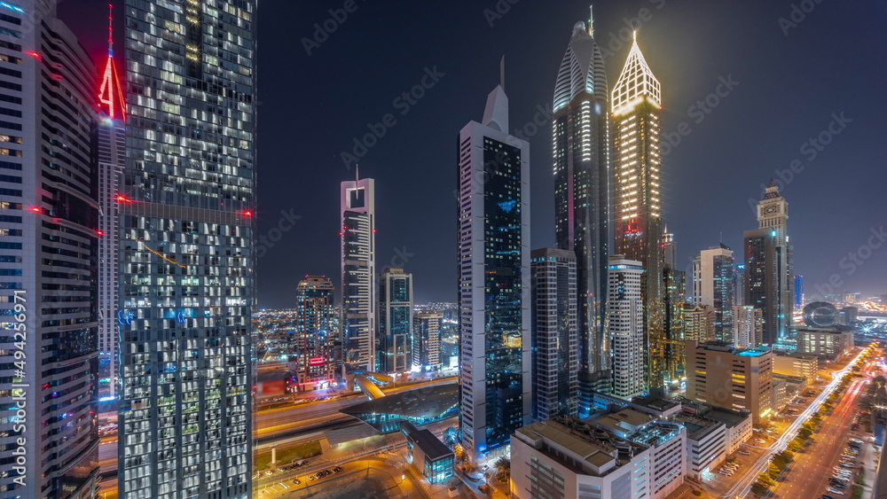Fototapeta premium Aerial view of Dubai International Financial District with many skyscrapers all night timelapse.