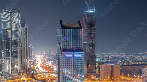 Dubai city skyline panoramic view with metro and cars moving on city's busiest highway aerial all night timelapse