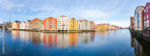 Wide panoramic view of old colorful wooden houses along river Nidelva in the Brygge district in Trondheim, Norway