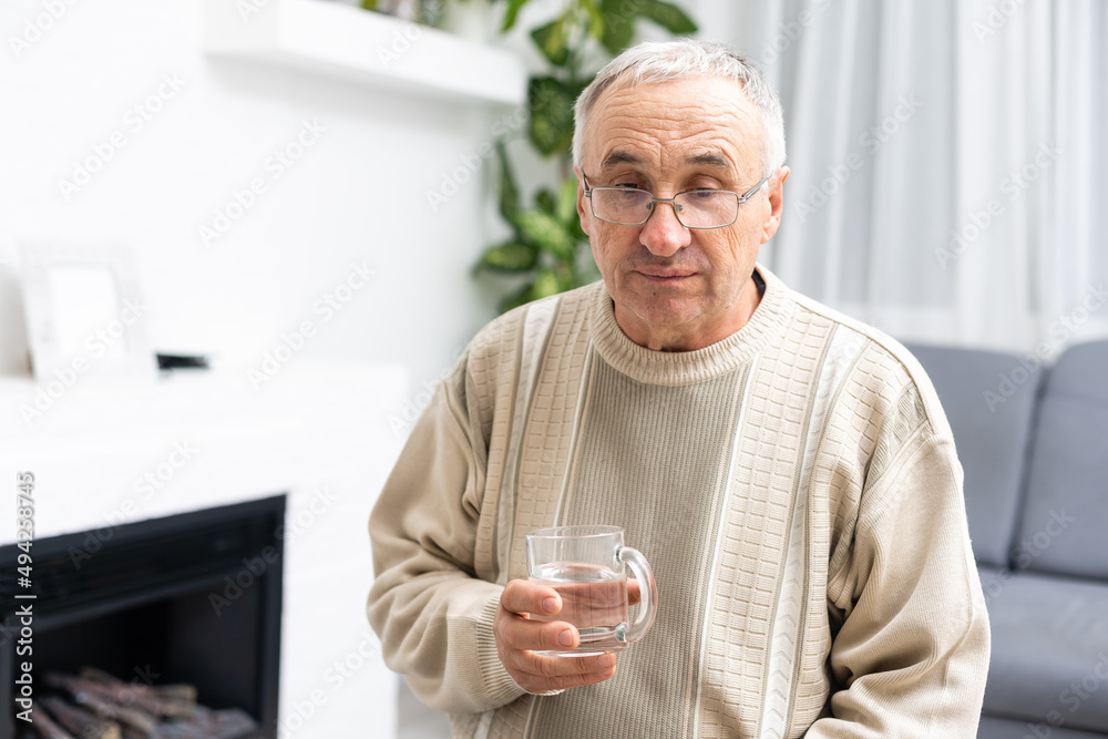 Male senior citizen in shirt drinking water Male senior citizen in shirt drinking water