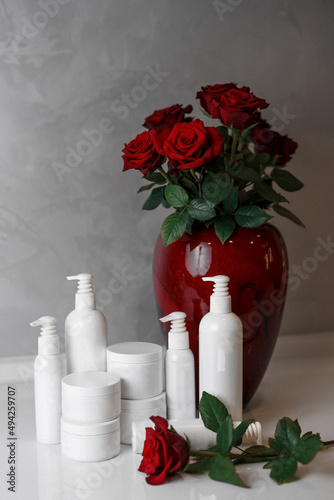 jars with cream, cosmetics, care products
on a background with flowers