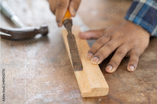 Wood undercut groov carpenter's hands work at home.