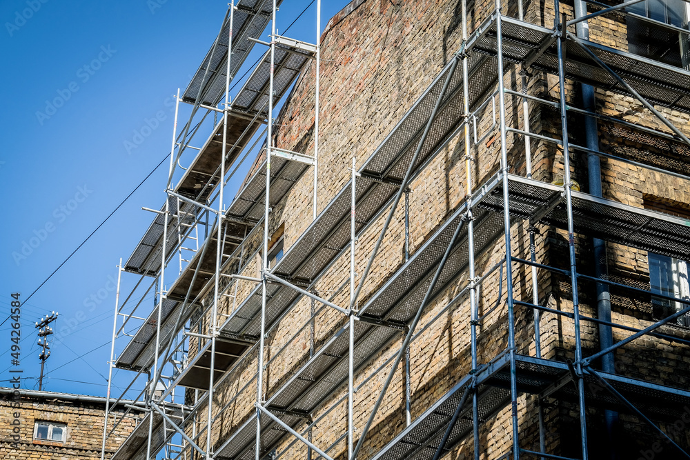 Reconstruction of an old brick house. Scaffolding for construction, construction site. Selective focus