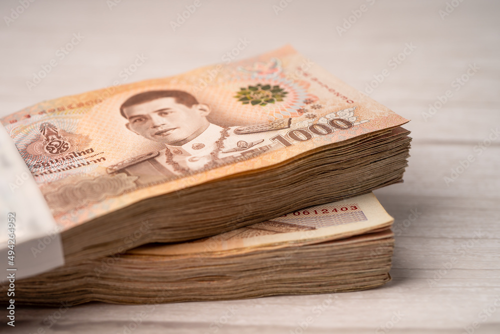 Stack of Thai baht banknotes on wooden background, business saving finance investment concept. Stack of Thai baht banknotes on wooden background, business saving finance investment concept.