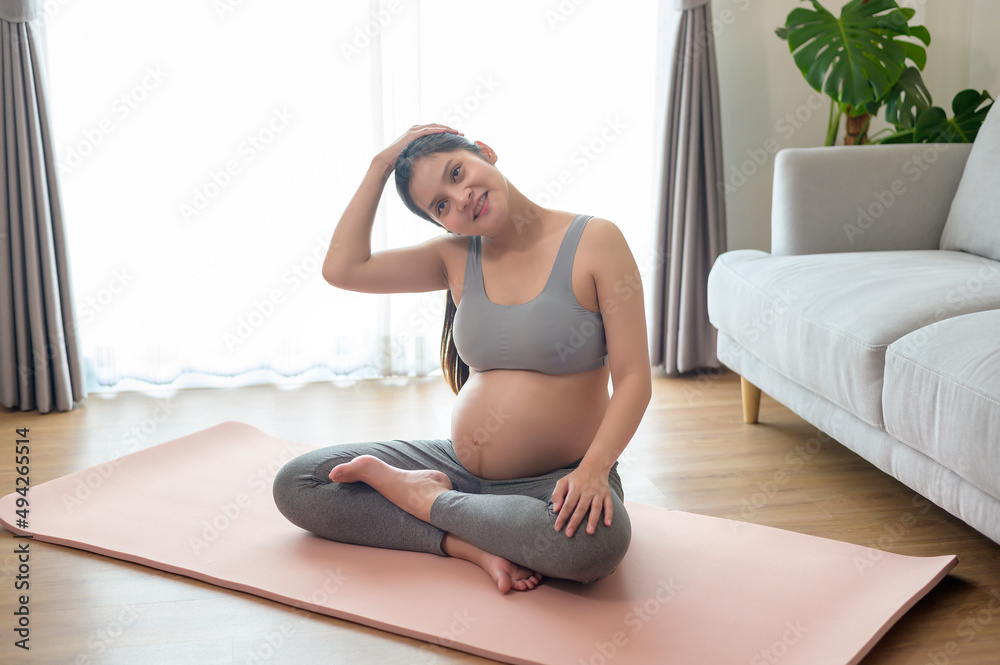 Young pregnant woman doing yoga at home, healthcare and pregnancy care concept Young pregnant woman doing yoga at home, healthcare and pregnancy care concept