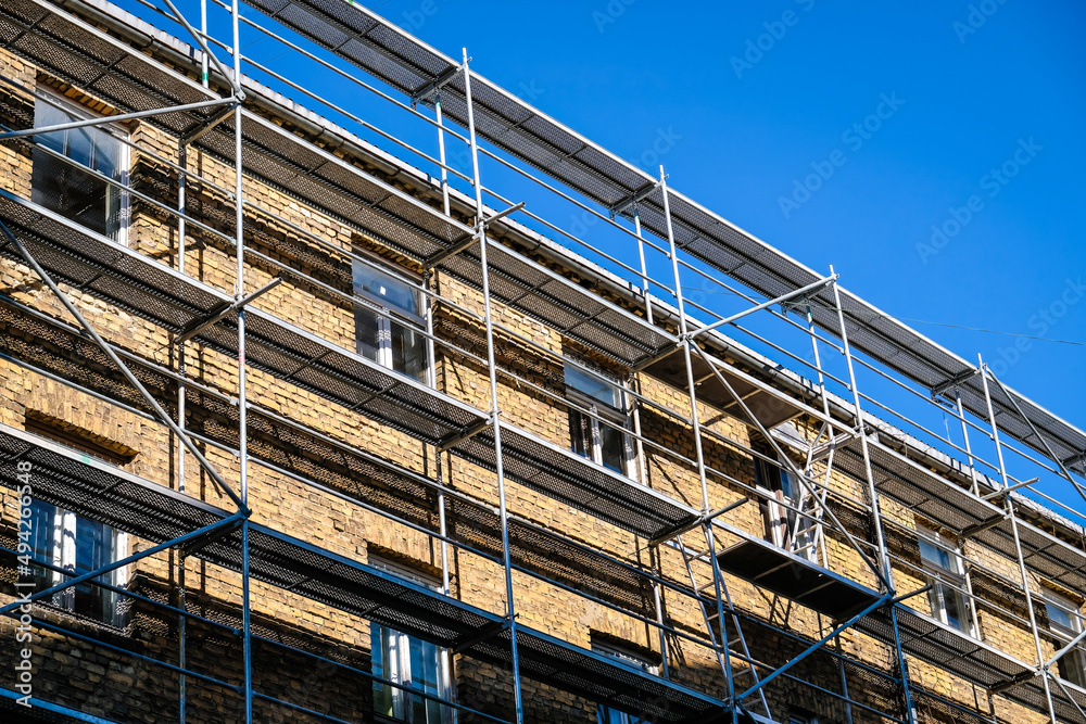 Reconstruction of an old brick house. Scaffolding for construction, construction site. Selective focus