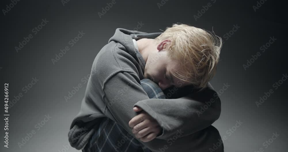 Hugging him self while crying and thinking Hugging him self while crying and thinking
