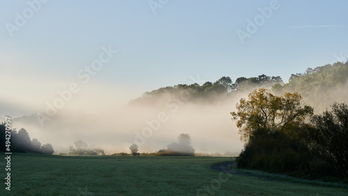 Nebelschwaden ziehen an einem sonnigen Herbstmorgen über das Lahntal