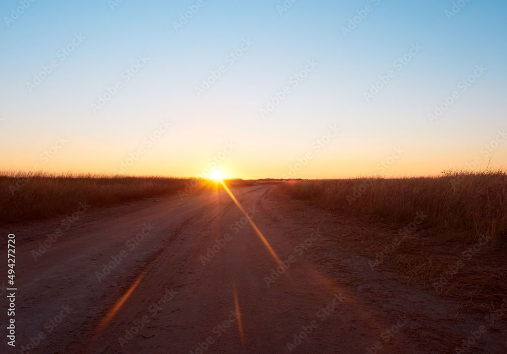 Fototapeta premium Sunrise in field with path on early autumn morning.