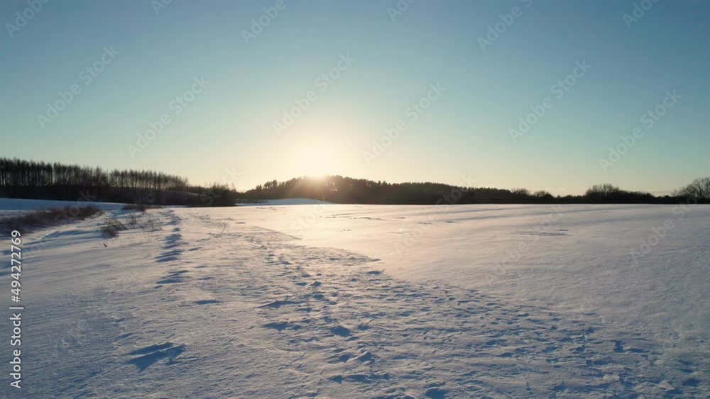 Aerial drone view of a fields covered with winter snow during sunset Aerial drone view of a fields covered with winter snow during sunset
