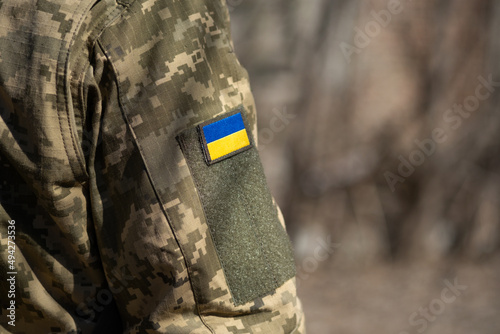 Ukrainian flag on a military uniform, war. Soldier Armed Forces of Ukraine. Territorial defense photo