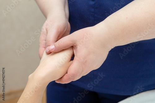 The masseur makes a hand massage, stroking the palm.The beauty master takes care of the skin of the hands. The beautician holds the client's fingers in his hands.Relaxing hand massage procedure