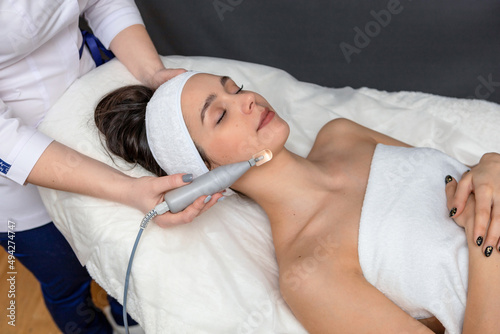 The girl in the cosmetologist's office lies on the couch and relaxes.Face and neck care in a beauty salon.Biomechanical stimulation from a cosmetologist.Care and rejuvenation procedure
