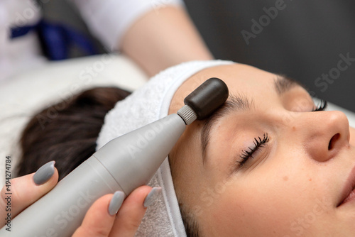 A girl's face in close-up during a facial treatment at a cosmetologist.The cosmetologist does biomechanical stimulation of the face to the client.Care and rejuvenation procedure