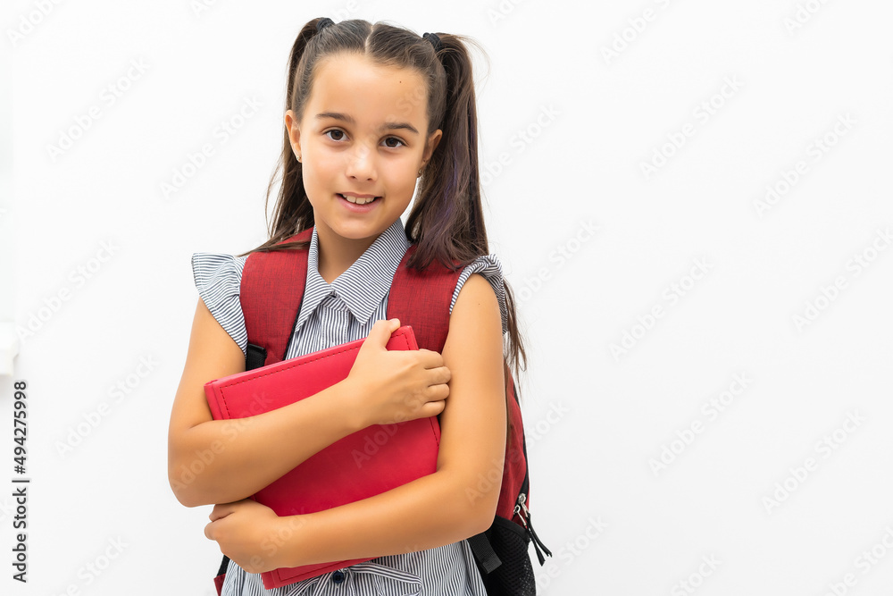 little girl isolated in white holding school book