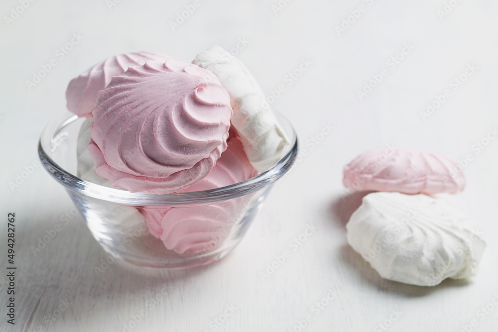 Pink and white Marshmallow dessert zephyr on the table. Meringue dessert in a glass bowl on the white background. traditional Russian sweet dessert. copy space.
