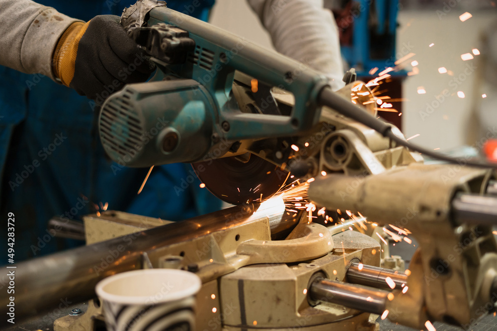 Technician worker cutting metal with many sharp sparks. Using equipments to cat iron Technician worker cutting metal with many sharp sparks. Using equipments to cat iron