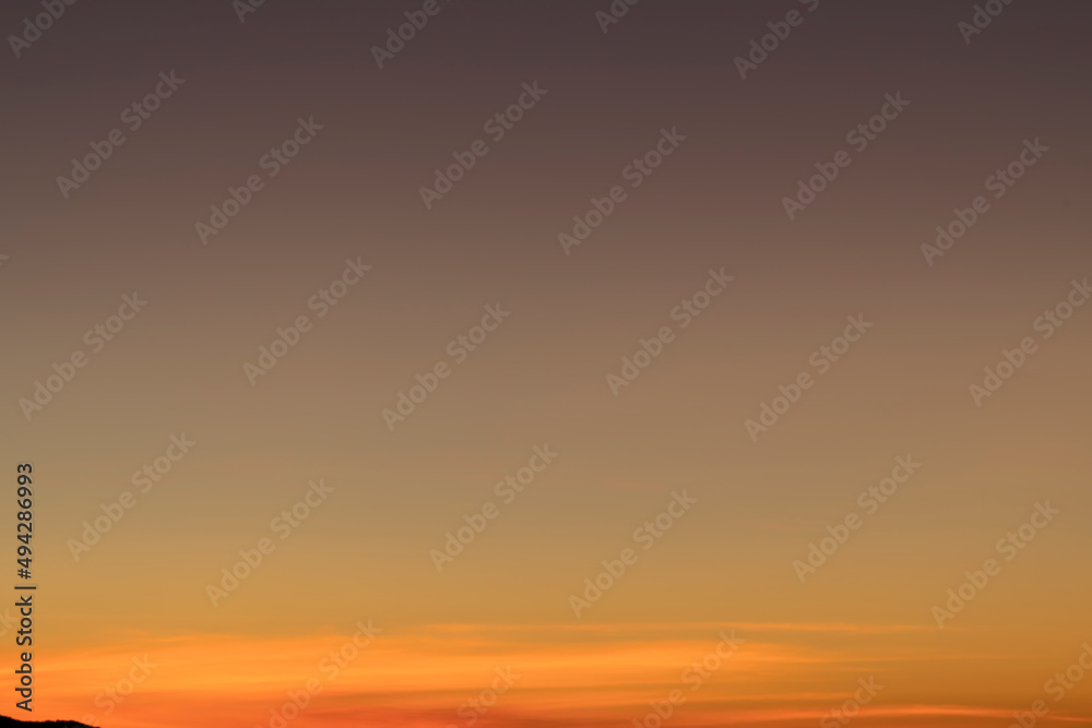 The sky before dawn was clear with an orange horizon and a blue atmosphere. orange dawn sky smooth orange gradient background of the start of the day Morning paradise with copy space. Sunset. Sunrise 
