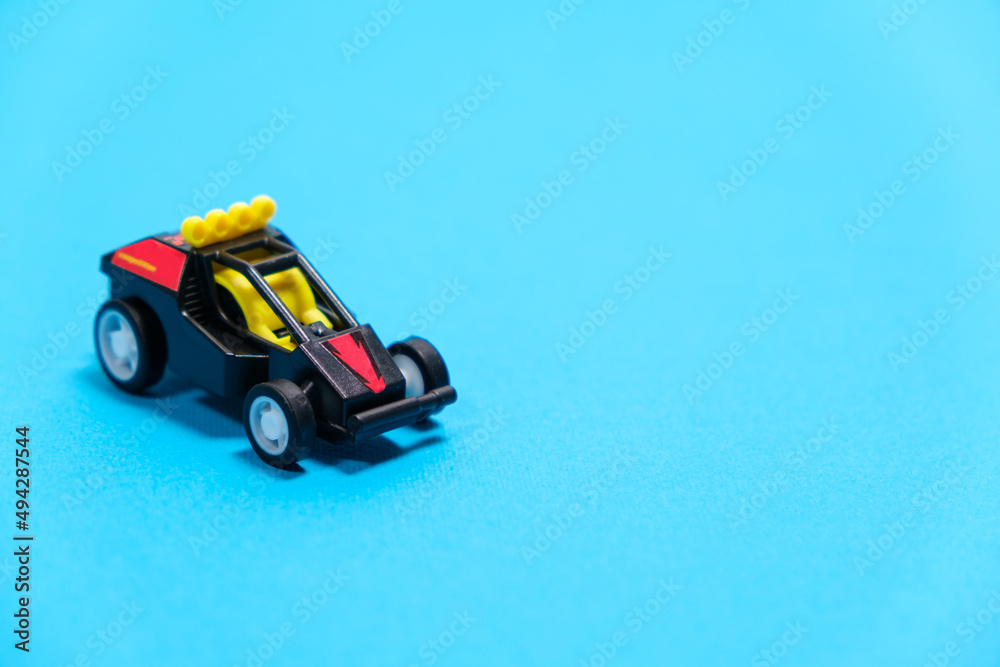 A black racing toy car on a blue background, a banner for a toy store with space for text A black racing toy car on a blue background, a banner for a toy store with space for text