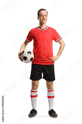 Man wearing football jersey and shorts and holding a ball