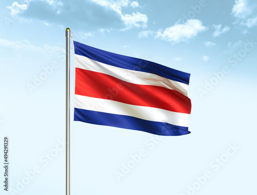 Free Download Costa Rica national flag waving in blue sky with clouds. Costa Rica flag. 3D illustration - GFXLoad