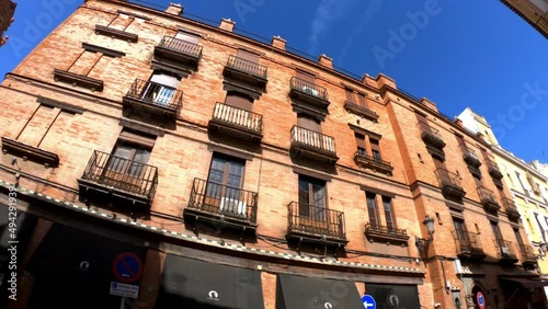 Sevilla, Spain, September 12, 2021: PAN SLOW MOTION SHOT - Colorful buildings of the Calle Arfe Street. photo